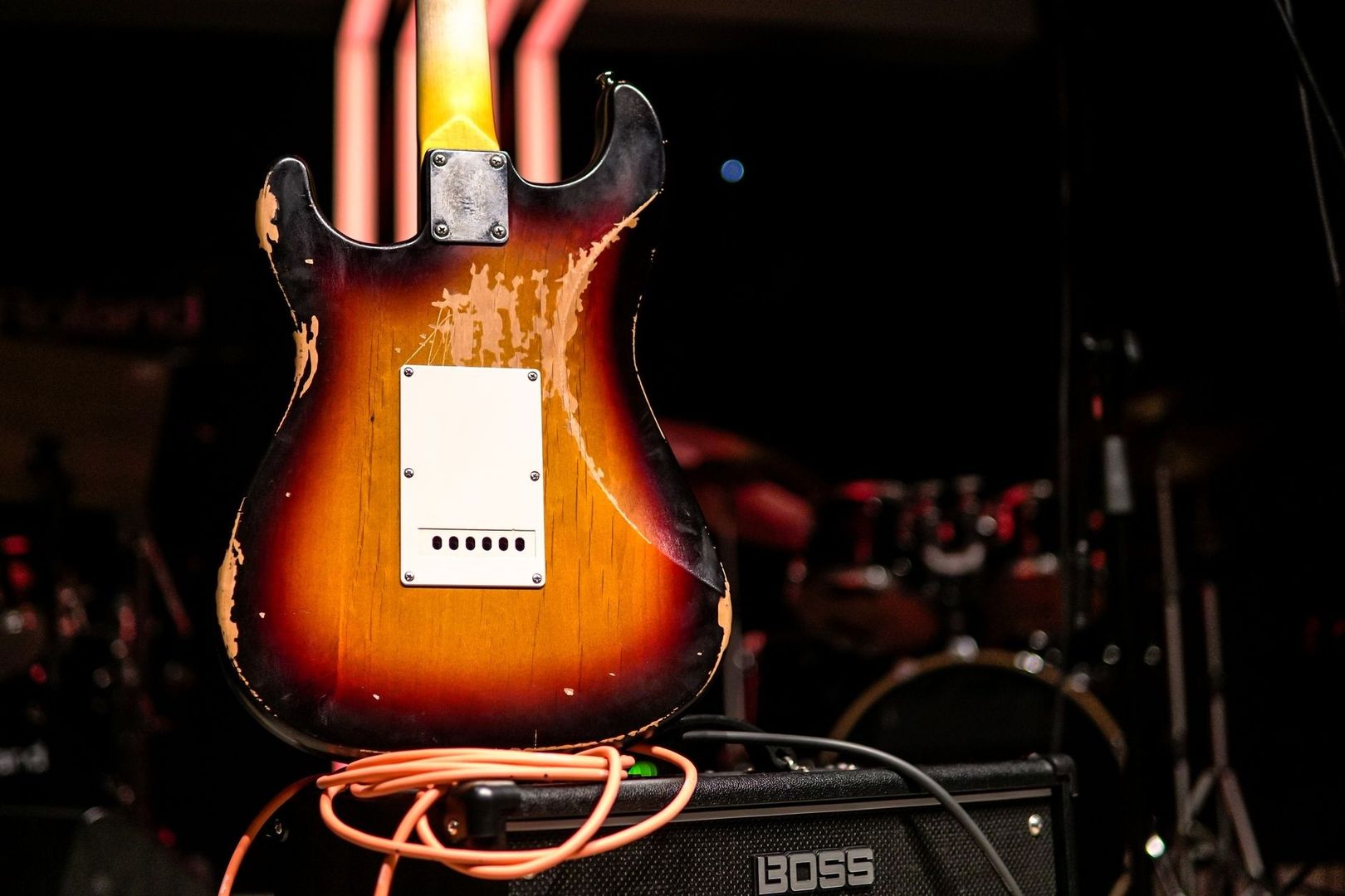 Versleten elektrische gitaar op een BOSS-versterker met kabel